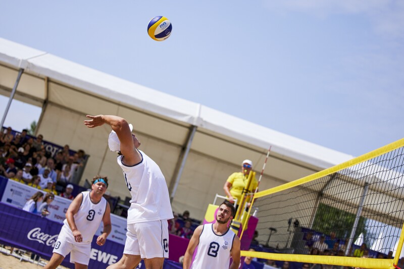 SO Serbia beach volleyball player jumps high to return a shot as his team mates look on during the men's/mixed unified sports team competition against SO Germany.