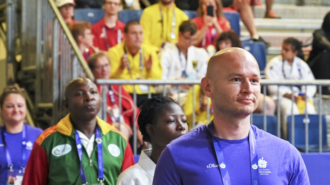 Auf dem Bild begleitet ein Volunteer zwei Judo-Athletinnen aus der Athletinnenzone zum Wettkampfplatz.