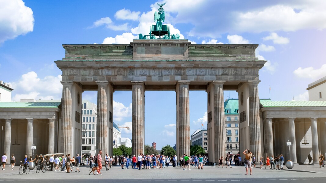 Das Foto zeigt Menschen vor dem Brandenburger Tor in Berlin.