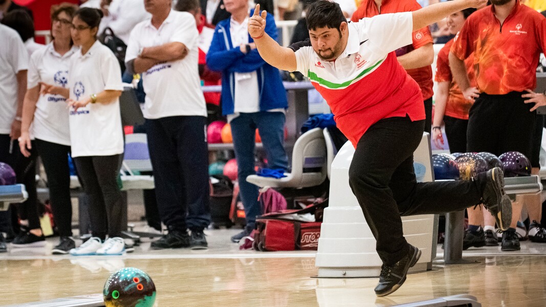 Das Bild zeigt einen Bowlingspieler, der gerade dynamisch seine Kugel auf den Weg geschickt hat.