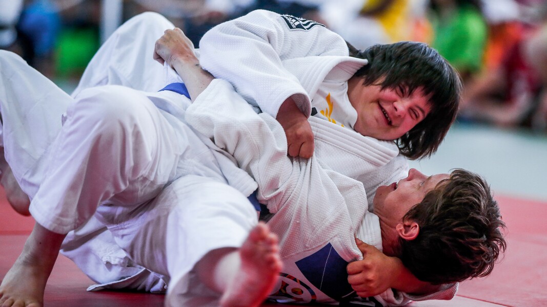 On the photo, there are two athletes during a Judo competition.