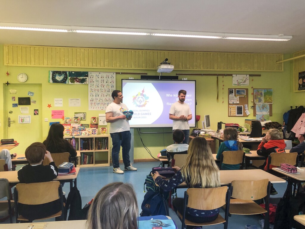 Auf dem Foto sind zwei Mitarbeiter des LOC zu sehen. Sie halten einen Vortrag in einer Schule zum Thema Inklusion
