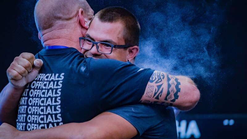 The photo shows a sports official and an athlete embracing.