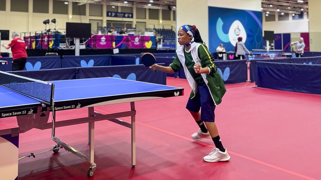 The photo shows a female table tennis player. She seems to be concentrated.