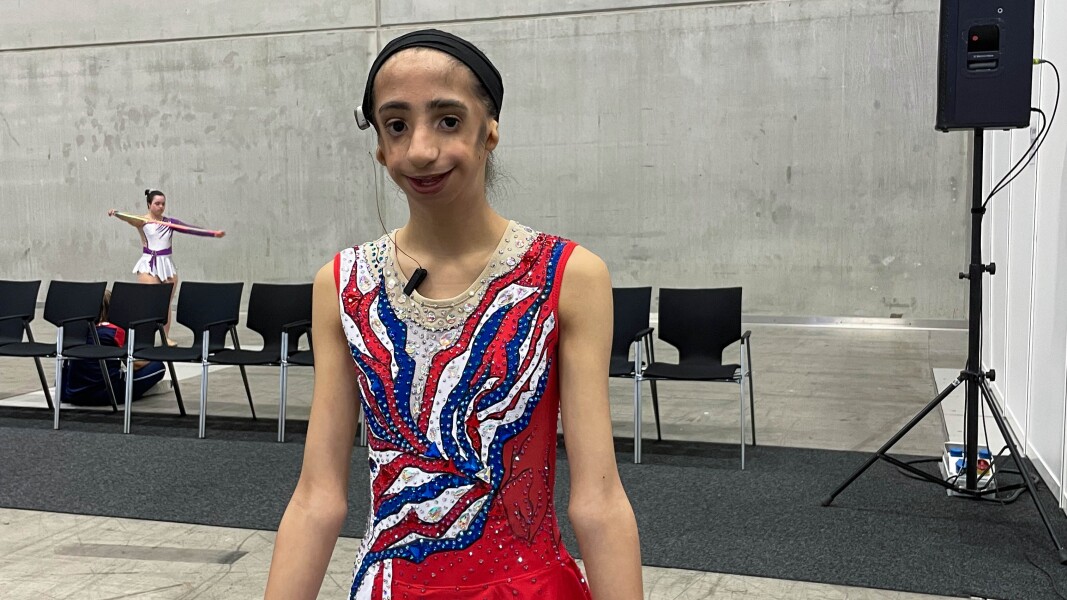 On the picture you can see a young athlete at the rhythmic gymnastics competition.