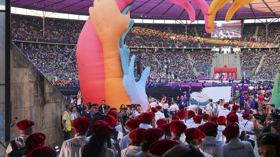 The photo shows athletes of the French delegation shortly before entering the stadium. Everyone is excited and cheering.