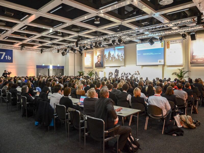 The photo shows many people during a presentation