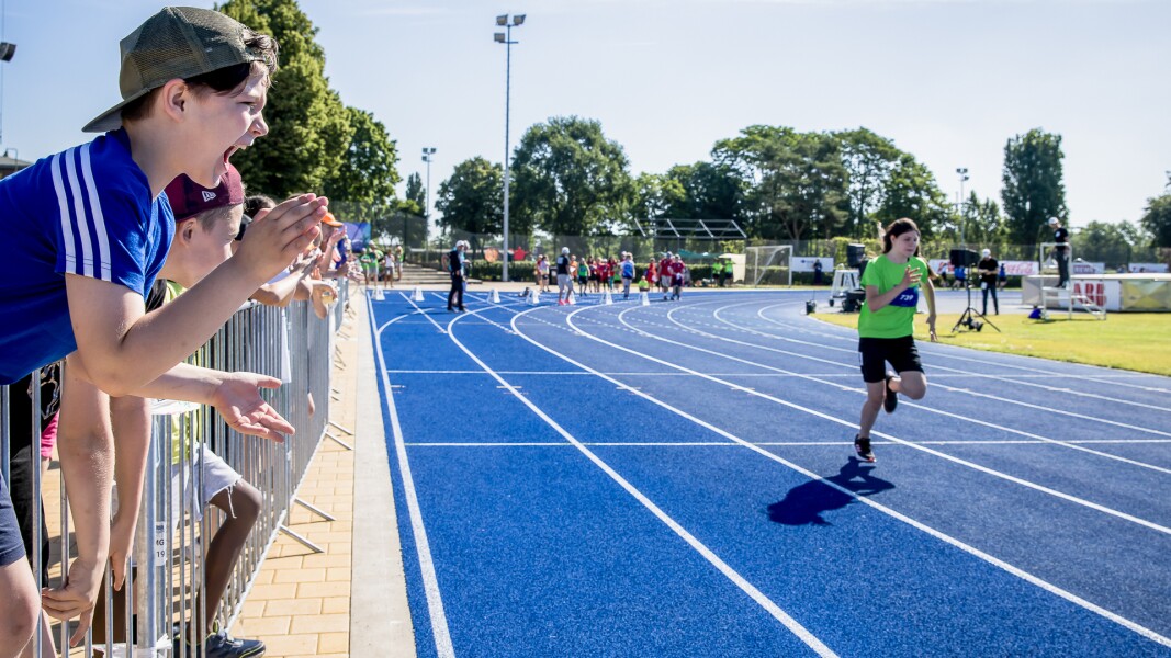 Auf dem Foto ist zu sehen: Schüler*innen des Inklusiven Campus Spandau feuern die Athlet*innen bei der Leichtathletik an. Sie haben beim "Fans in the Stands" Programm mitgemacht.
