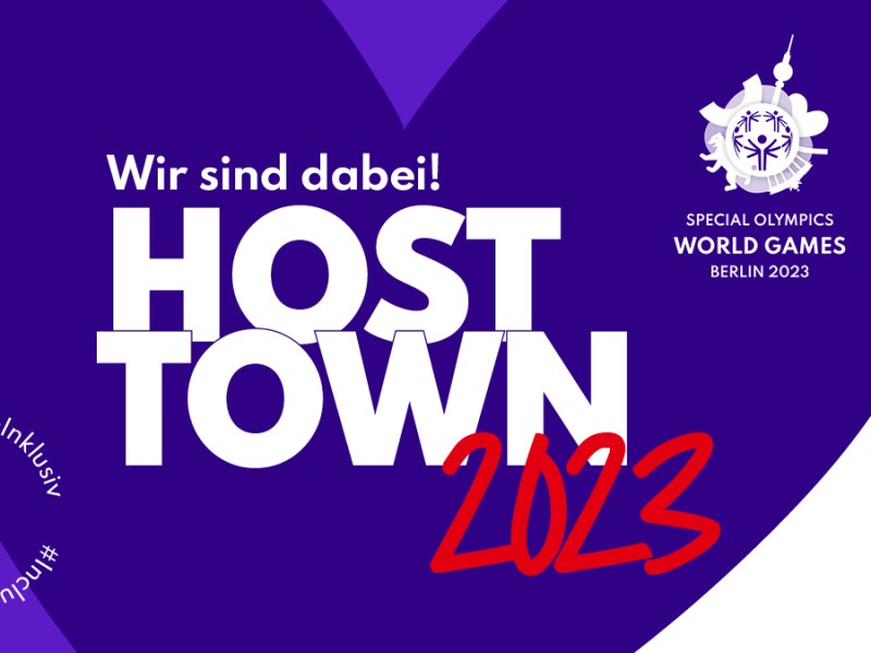 Die Grafik zeigt ein lilanes Herz auf dem "Wir sind dabei! Host Town 2023" steht. Außerdem ist unten links der Hashtag #ZusammenInklusiv sowie oben rechts das Weltspiele-Logo zu sehen.