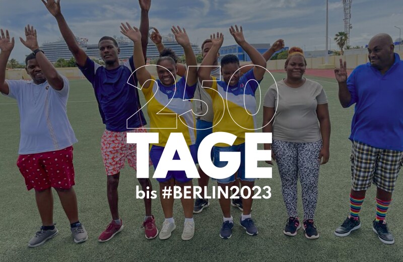 Auf der Grafik steht "250 Tage bis #Berlin2023". Im Hintergrund ist ein Foto von mehreren jubelnden Menschen zu sehen.