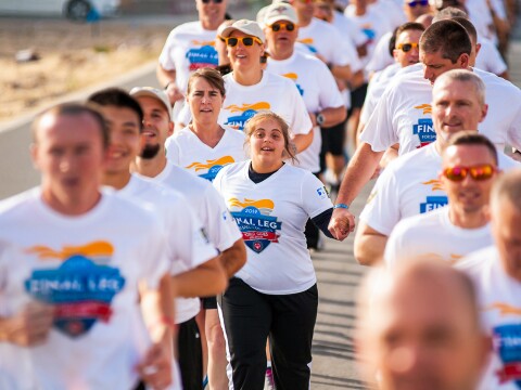 In the photo, many people are running hand in hand. It is the last round of the torch relay.
