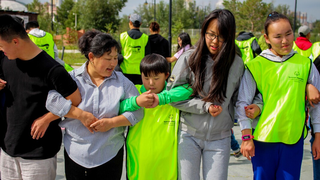 The photo shows families and athletes holding each other by the arms.