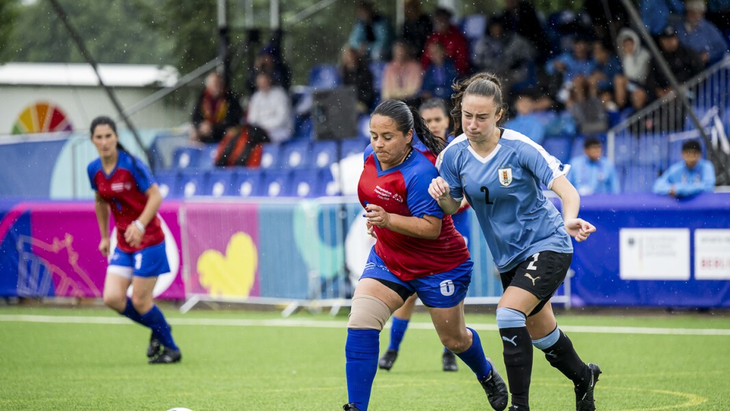 Auf dem Foto sind zwei Futsal-Spielerinnen in Action zu sehen. Sie sind im Zweikampf um den Ball.