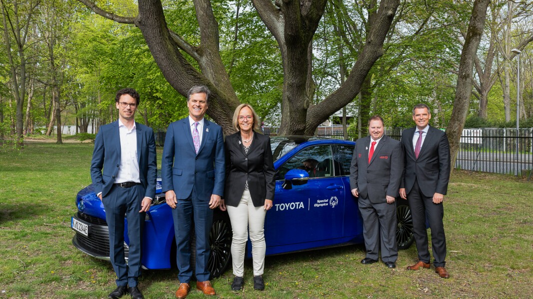 Das Foto zeigt fünf Menschen, die vor einem Auto stehen und lächeln. Das Auto ist ein Toyota, weil Toyota die Special Olympics Events in Berlin sponsort.