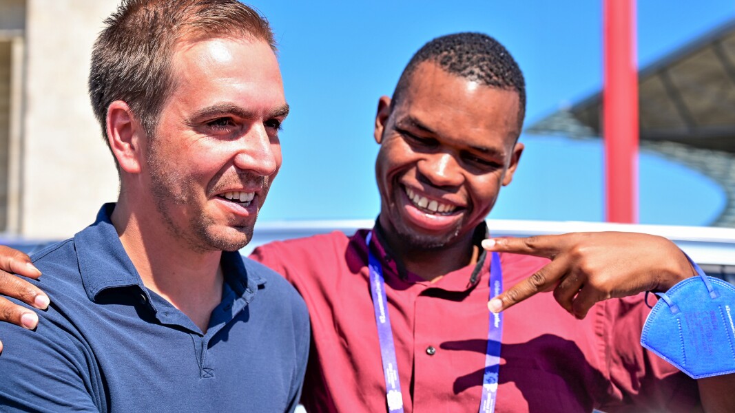 Auf dem Foto sind Ex-Nationalspieler Philipp Lahm und Global Athlete Ambassador Nyasha Derera. Sie umarmen sich freundschaftlich und lächeln.