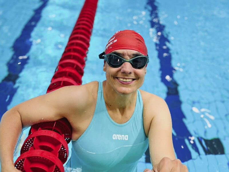 The photo shows a swimmer at the training day. She is beaming in the face.