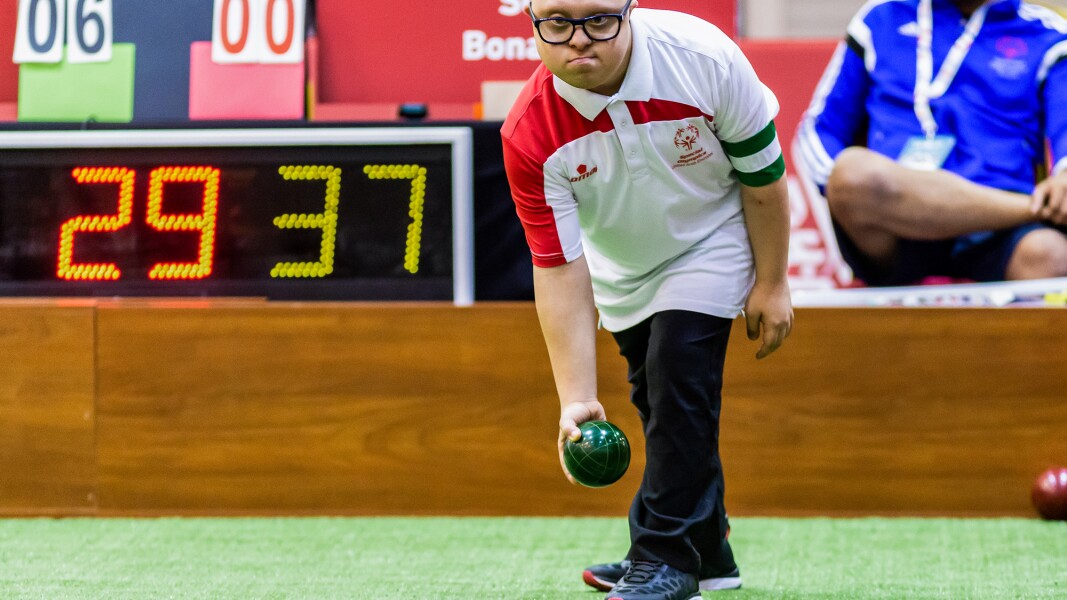 Auf dem Foto ist ein Boccia-Spieler zu sehen, der konzentriert eine Kugel hält und bald werfen wird.