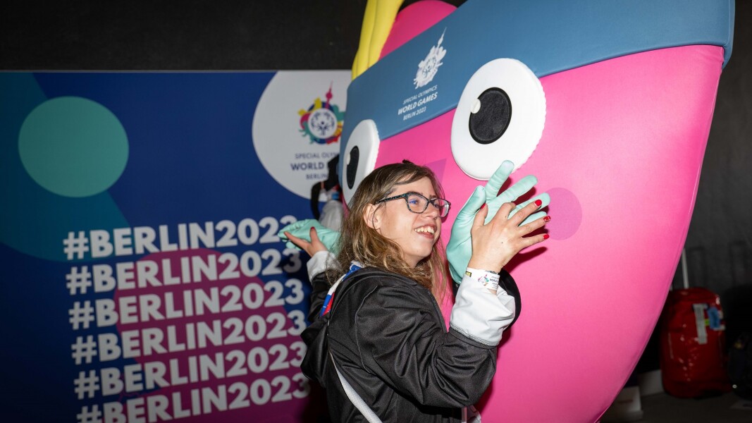 Das Foto zeigt eine junge Teilnehmerin der US-Delegation, die das Maskotchen der Special Olympics, UNITY, herzlich umarmt.