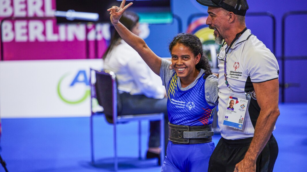 On the picture you can see a female athlete smiling after the execution of a deadlift.