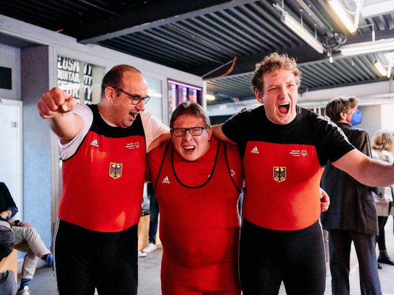 In the photo, three Special Olympcis Germany athletes are cheering for the camera. They have just learned that they will be allowed to compete for Team SOD at the World Games in powerlifting.