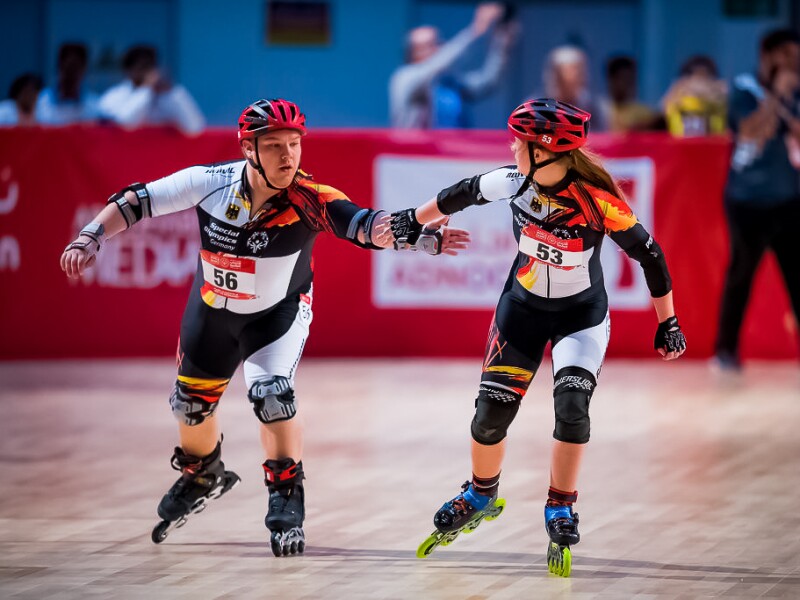 Das Foto zeigt einen Athlet und eine Athletin beim Roller Skating.