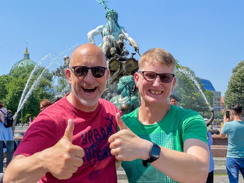 Das Foto zeigt Athletin Michaela Marynik und ihren Trainer beim Special Olympics Festival. Sie halten beide ihren Daumen hoch und lachen vergnügt.