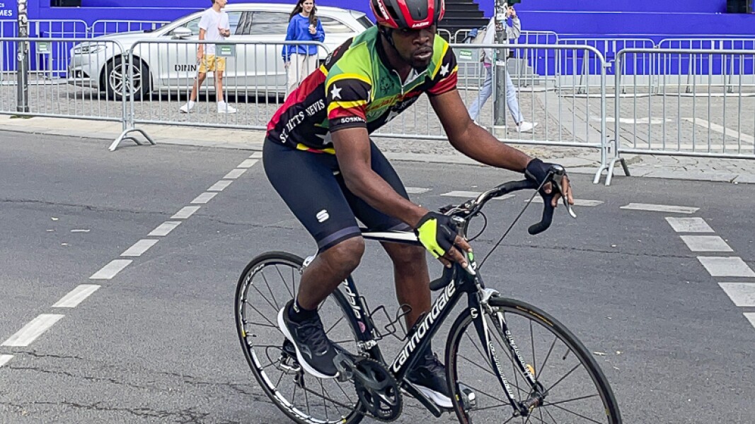 The photo shows an athlete riding a bicycle. He looks concentrated.