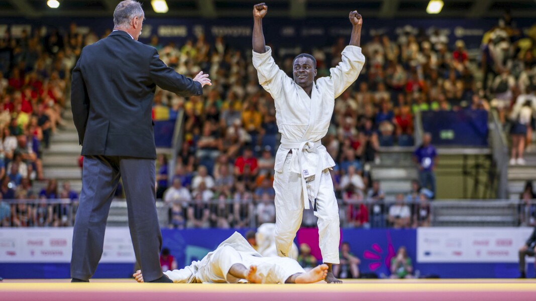 Auf dem Bild liegt ein Judo-Kämpfer am Boden. Ein weiterer Judo-Kämpfer hebt jubelnd die Hände.