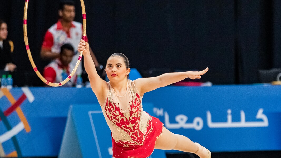 The photo shows an athletes with a hoop during her Gymnastics-Rhythmic competition.