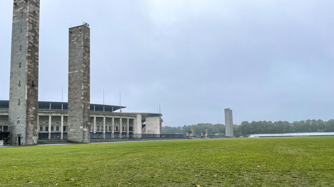 The photo shows a lawn in the foreground and two large columns, and parts of the Berlin Olympic Stadium.