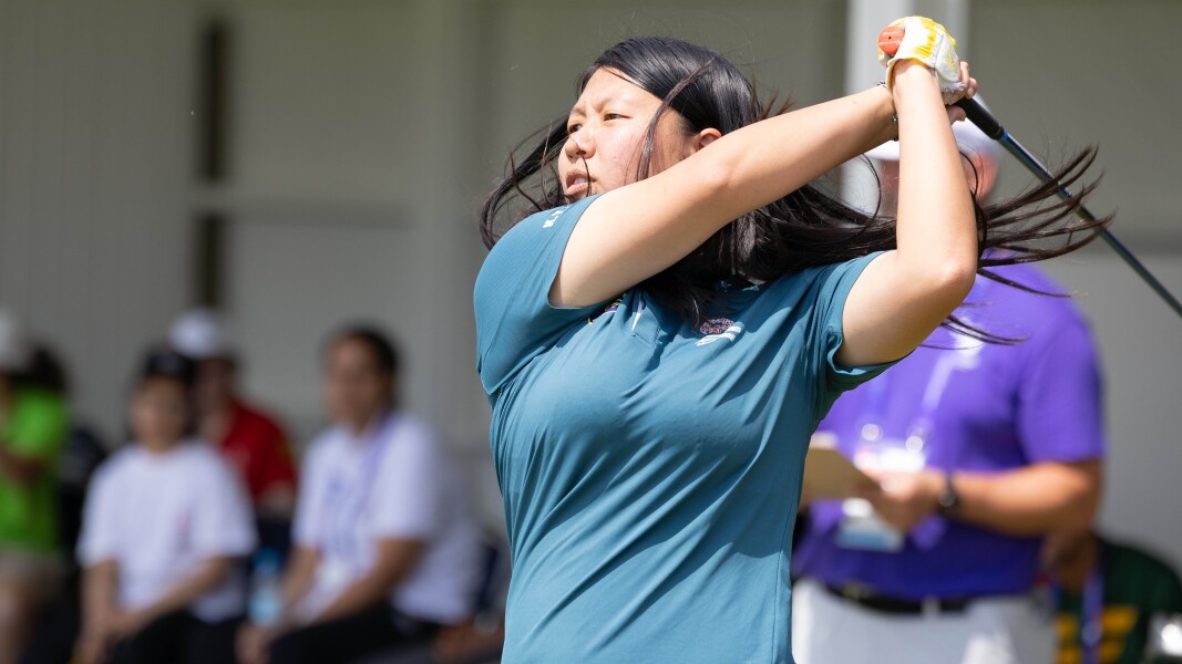 Hong Kong female athlete Ka Yin Wong focussing on the ball after swinging the golf club