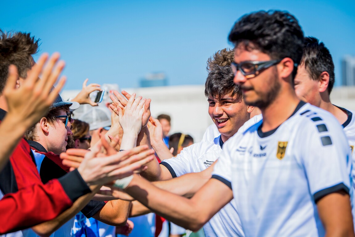 Das Foto zeigt das deutsche Fußball-Team. Es lässt sich von den Fans feiern und begrüßt diese mit Handschlag.