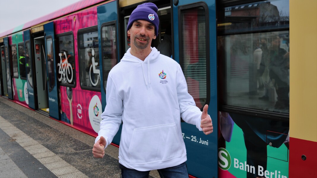 Auf dem Foto ist Robert Herberg vor der beklebten S-Bahn zu sehen. Er zeigt die Daumen nach oben und lächelt.