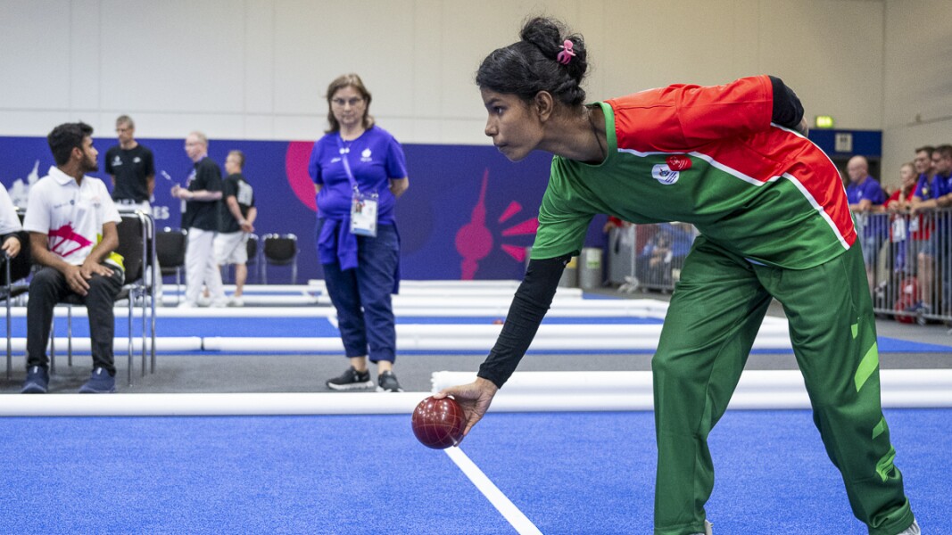 The photo shows a bocce player just concentrating on her next throw.