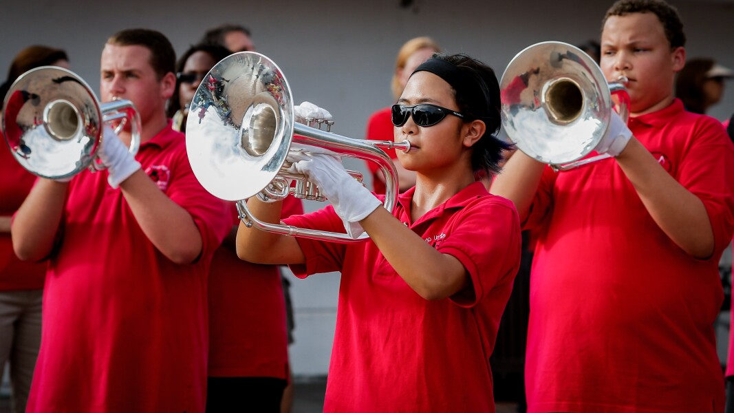 The photo shows a music group playing the trumpet.