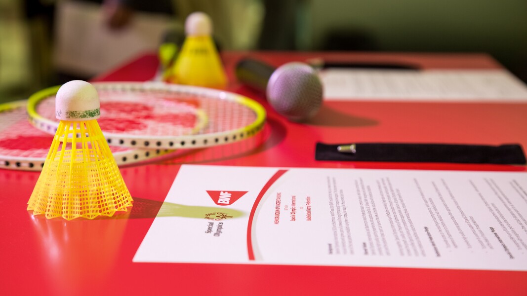 Das Foto zeigt eine generische Badminton-Szene: auf einem Tisch liegen Schläger und Federbälle.