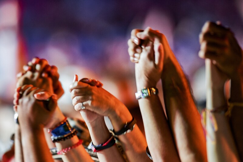 The photo shows many people holding hands.