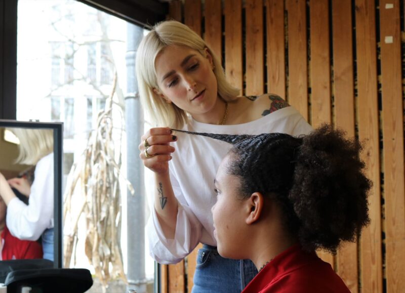 Auf dem Foto ist eine Athletin zu sehen in der Maske vor dem VOGUE Shooting. Sie sieht entspannt und freudig aus.