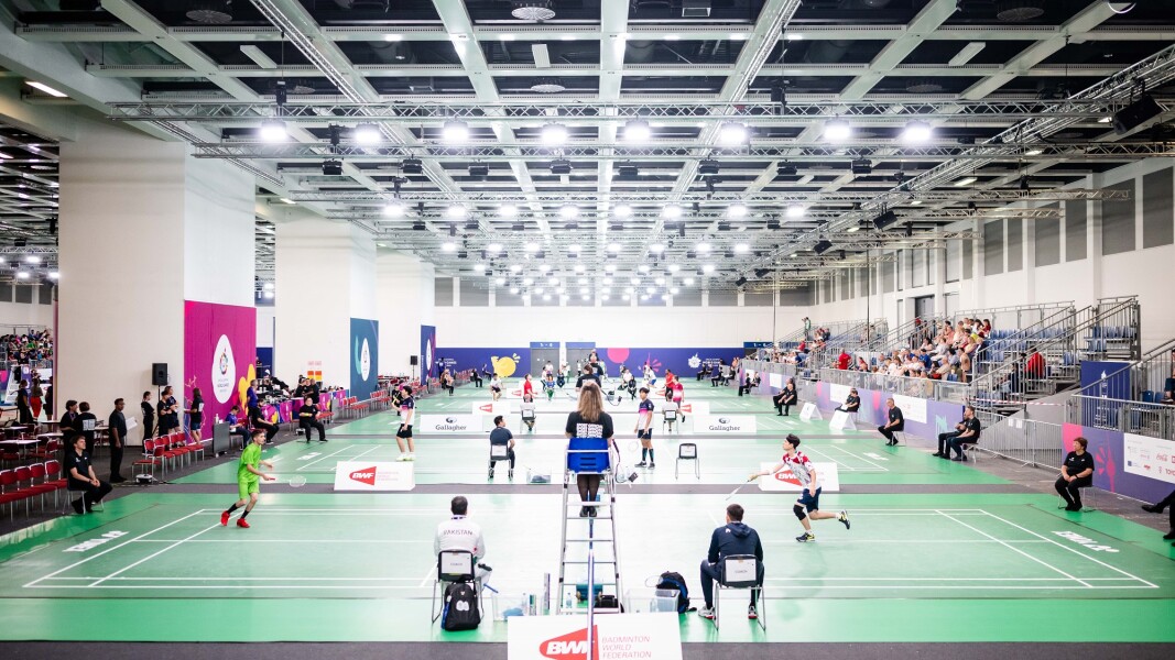 Die Athleten treten gegeneinander in der Sportart Badminton an.