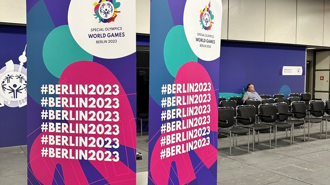 The picture shows the entrance area of the UDAC. In the background are waiting chairs, while in front is a large advertising stand in the colors and with the logo of the Berlin 2023 Games.