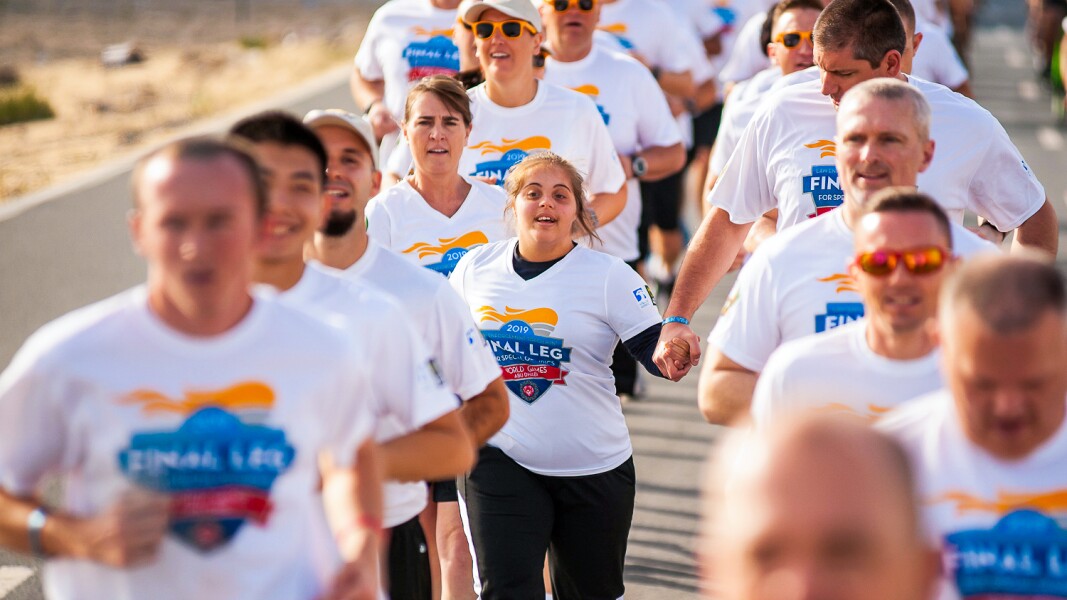 In the photo, many people are running hand in hand. It is the last round of the torch relay.