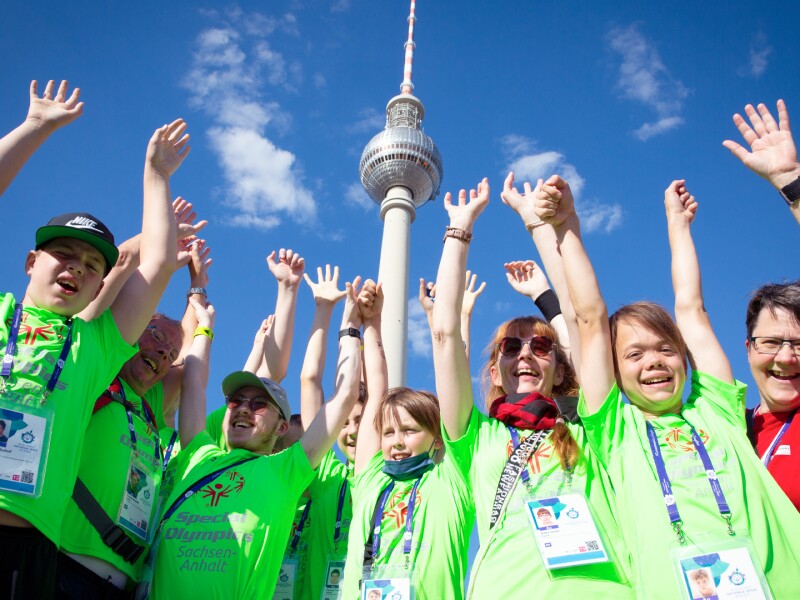 The photo shows a group of 0´9 athletes celebrating at the Special Olympics Festival right in front of the TV tower at Alexanderplatz.
