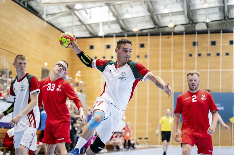 Das Foto zeigt eine Szene aus dem Handballspiel, bei der ein ungarischer Spieler im weißen Trikot gerade mit fast ausgestrecktem Arm zum Wurf ansetzt.