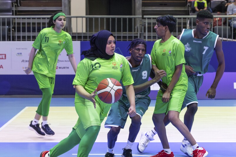 On the picture you can see basketball athletes playing against each other.