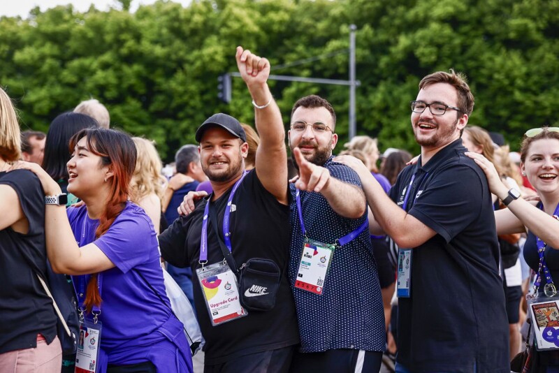 Das Foto zeigt Volunteers jubelnd in einer Polonaise. 