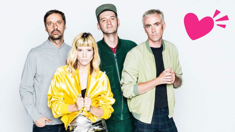 The photo shows the Berlin cult band MiA., which will perform at the Opening Ceremony of the National Games. The four band members are looking at the camera. In the corner is additionally placed a pink heart.