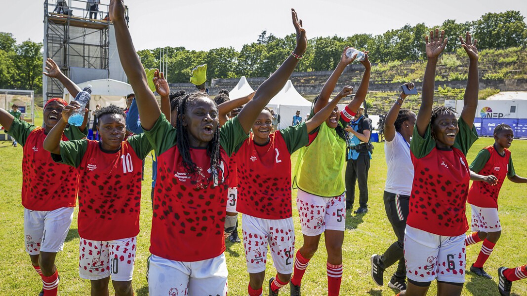 Das Foto zeigt ein jubelndes Frauenfußballteam. Sie reißen ihre Hände nach oben.