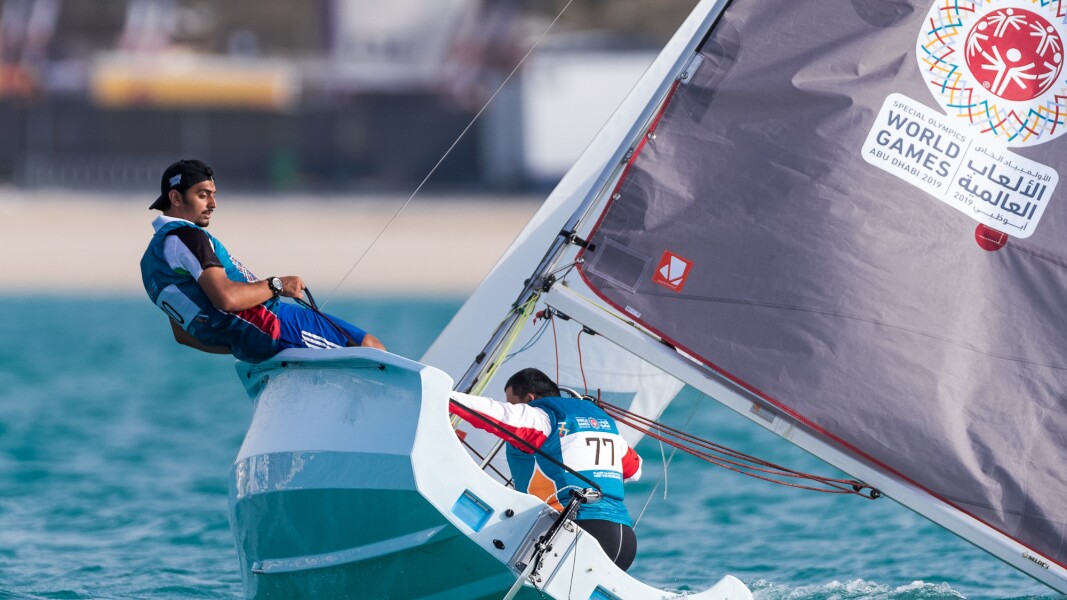 Das Foto zeigt zwei Athleten beim Segeln. Sie haben Fahrt aufgenommen und ein Athlet muss sich sehr anstrengen, damit das Boot im Wind fährt.