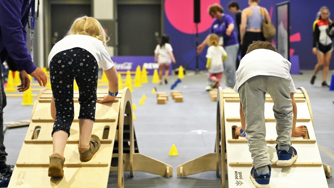 Auf dem Foto sind zwei Kinder zu sehen. Die Kinder klettern über eine Hürde bei der Activity-Zone.