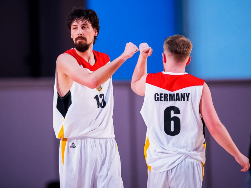 Two Basketball players give each other a fist bump during a match.
